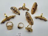 a group of gold rings and rings on a white surface