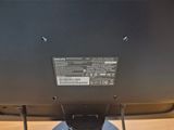 the back of a computer monitor sitting on top of a wooden desk