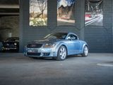 une voiture bleue garée dans un garage avec d'autres voitures