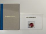 two books on a white table with a red ring on top of it