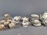 many cups and saucers and a teapot on the table