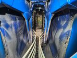 the inside of a blue train car with pipes running through it
