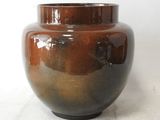 a large brown vase sitting on a white surface