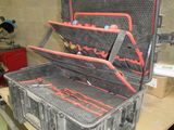 une valise noire avec des poignées rouges posée sur une table
