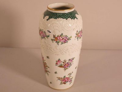 un vase blanc orné de fleurs roses, posé sur une table