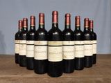 six bottles of wine are lined up on a wooden table