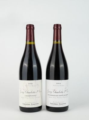 two bottles of red wine sitting next to each other on a white surface
