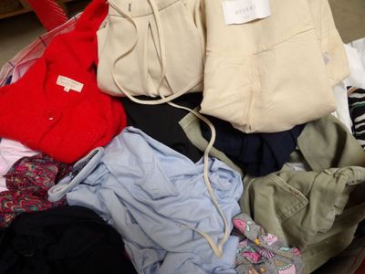 a suitcase full of clothes and a handbag on the floor