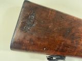 an old wooden rifle is laying on a white surface