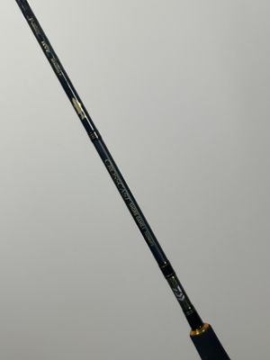 a close up of a black and gold badminton racket on a white surface