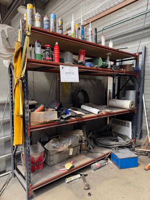 une étagère sur laquelle sont posés de nombreux objets, dans un garage