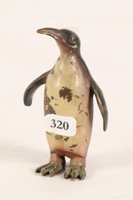 a small bronze penguin with a tag on it ' s neck