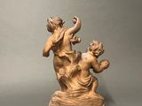 bronze statue of a woman and a child playing with a bird