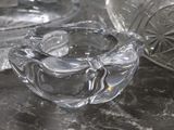 a glass ashtray and a glass bowl on a table