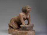 an image of a statue of a monkey sitting on a rock