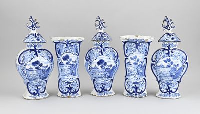 quatre vases bleus et blancs sont alignés sur un fond gris