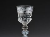 glass goblet in the shape of a cup with a design of flowers and leaves