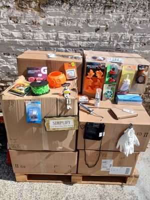 une pile de cartons posée par terre à côté d'un mur de briques