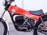 a red and black motorcycle parked in front of a wall