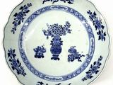 a blue and white plate with a bird and flowers on it