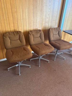 trois chaises dans une pièce où se trouvent une table et une chaise placées face à un mur