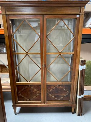 a cabinet that has a glass door on top of it