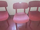three red chairs sitting next to each other on a red floor