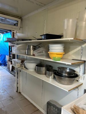 de nombreuses casseroles et poêles sur les étagères de la cuisine