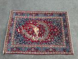 a red rug with a bird and flowers on it