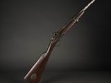 un vieux fusil avec un canon en bois et une poignée en métal