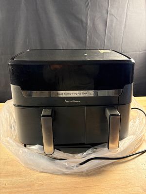 une friteuse à air chaud posée sur une table en bois, à côté d'un sac en plastique