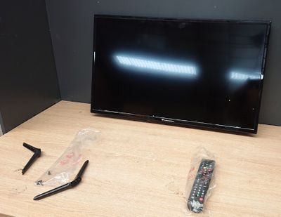 deux télécommandes et un téléviseur posés sur une table