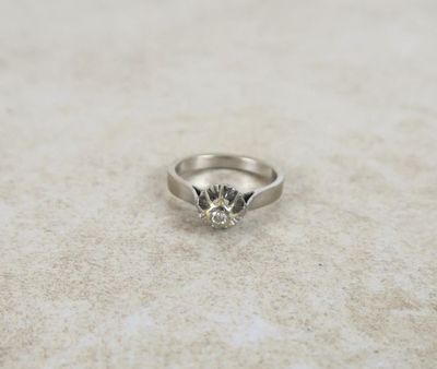 a close up of a diamond ring sitting on a table