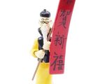 figurine of a man holding a red scroll with chinese writing