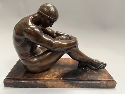 statue d'un homme assis sur un socle de marbre, les mains posées sur les genoux