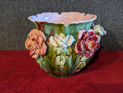 un vase vert orné de fleurs, posé sur une table rouge