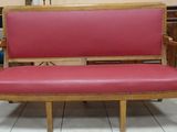 a red couch that is sitting on a tile floor