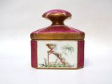 a small pink and gold box with a painting on it