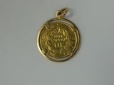 a close up of a gold coin on a white surface