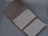 leather wallet on a table with a notepad and pen in it