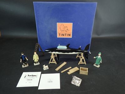 figurines représentant des personnes debout devant une cabine bleue