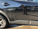 a man taking a picture of himself in the reflection of a car