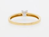 a close up of a yellow gold engagement ring with a single diamond