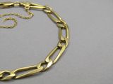 un gros plan d'un collier en or avec une chaîne posé sur une table