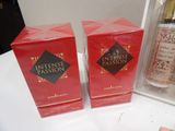 two boxes of perfume sitting on a table next to each other
