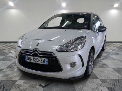 la petite voiture blanche est garée sur un carrelage à carreaux