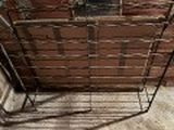 un panier en fil de fer posé par terre, avec un chat à l'intérieur