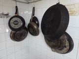 casseroles et poêles accrochées au mur de la cuisine