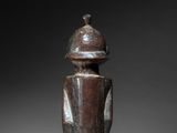 a wooden statue of a man with a hat on his head