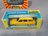 two yellow toy cars are sitting in a box on a table